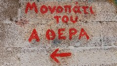 «The Trail of Atheras» – painted on a wall of concrete blocks in Oxe village, Ikaria